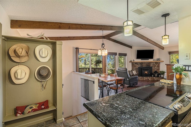 kitchen featuring vaulted ceiling with beams, a textured ceiling, a stone fireplace, range with electric stovetop, and visible vents