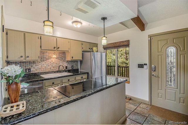 kitchen featuring a sink, visible vents, appliances with stainless steel finishes, backsplash, and stone tile flooring