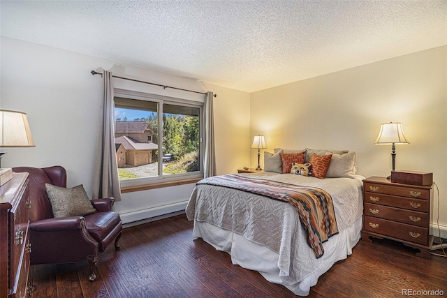 bedroom featuring a textured ceiling, a baseboard heating unit, and wood finished floors