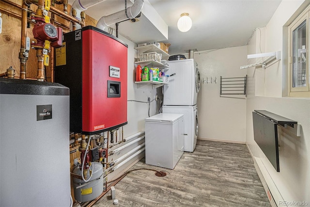 laundry room with stacked washer and dryer, water heater, baseboards, and wood finished floors