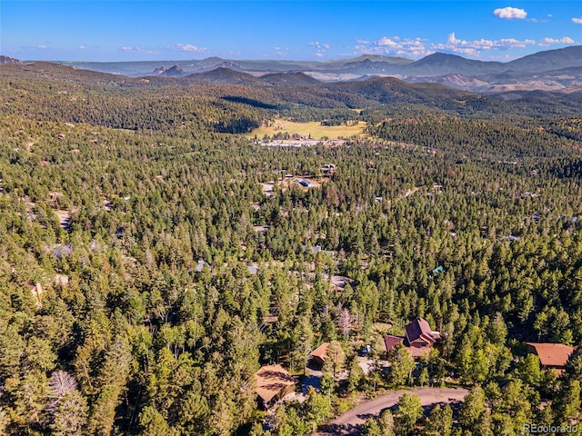 birds eye view of property featuring a mountain view and a view of trees