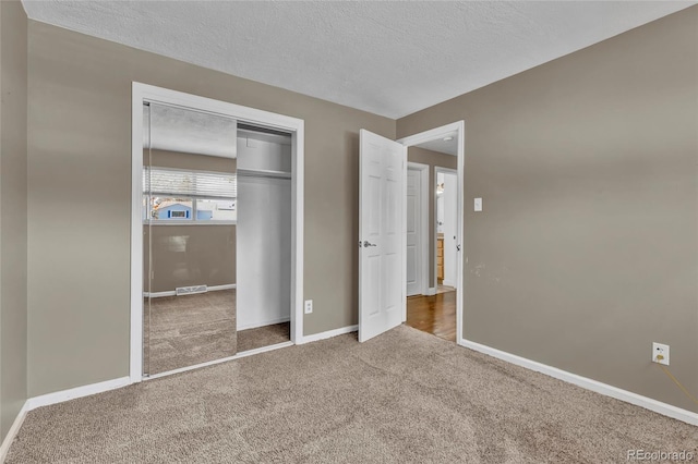 unfurnished bedroom with carpet flooring, baseboards, visible vents, and a textured ceiling