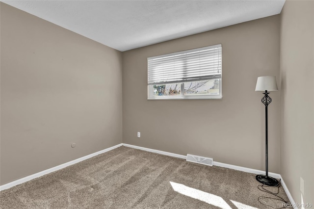 unfurnished room with visible vents, baseboards, a textured ceiling, and carpet flooring