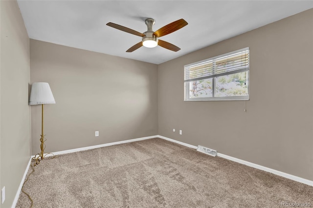 carpeted empty room featuring visible vents, baseboards, and a ceiling fan