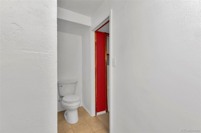 bathroom with tile patterned floors, toilet, and baseboards