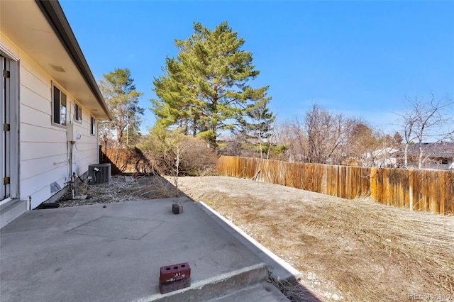 view of yard with a patio, central AC, and fence