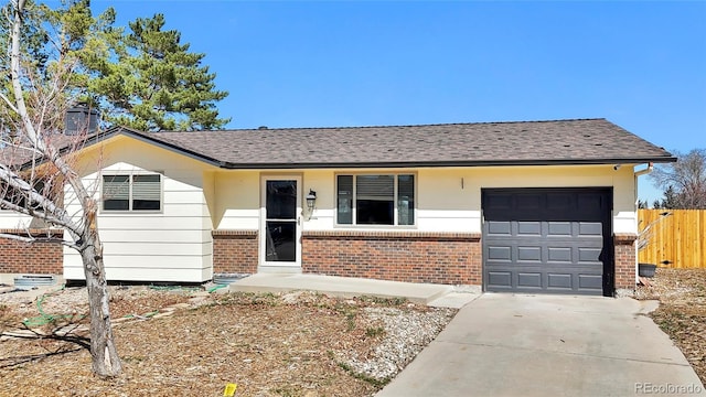 ranch-style house with brick siding, an attached garage, driveway, and fence