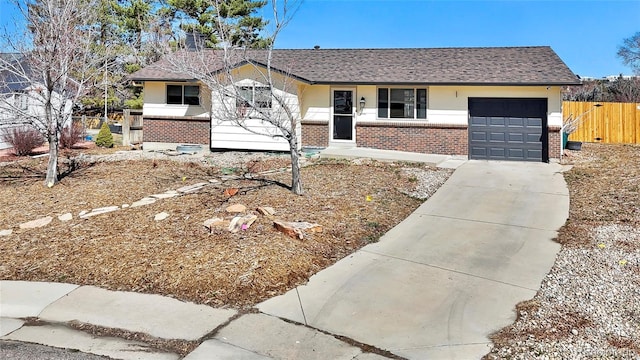 ranch-style house with an attached garage, fence, brick siding, and a shingled roof