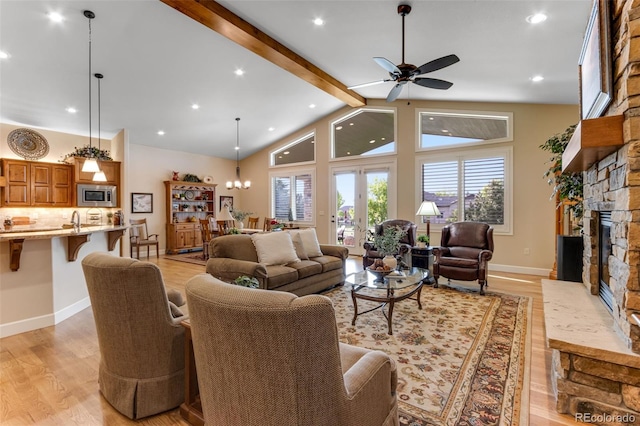 7992 Rising Sun Ct, Windsor, CO 80550 - living room with a stone fireplace, light wood-type flooring, beam ceiling, ceiling fan, and baseboards