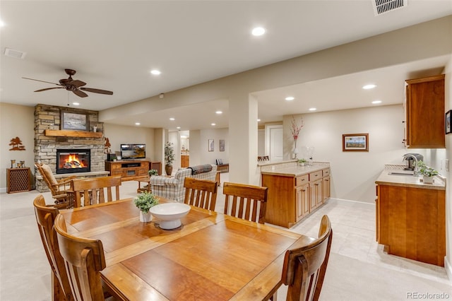7992 Rising Sun Ct, Windsor, CO 80550 - dining room featuring recessed lighting, a stone fireplace, ceiling fan, light colored carpet, and baseboards