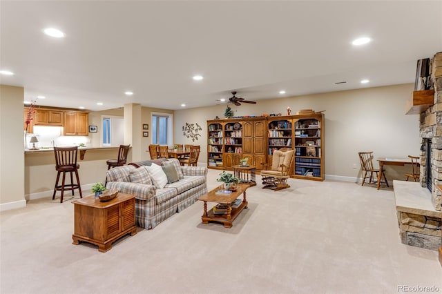 7992 Rising Sun Ct, Windsor, CO 80550 - living room featuring light colored carpet, recessed lighting, a stone fireplace, baseboards, and ceiling fan
