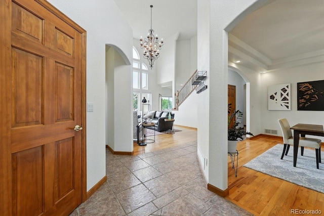 3 Desert Inn Way, Colorado Springs, CO 80921 - entrance foyer featuring arched walkways, baseboards, a chandelier, stairway, and wood finished floors