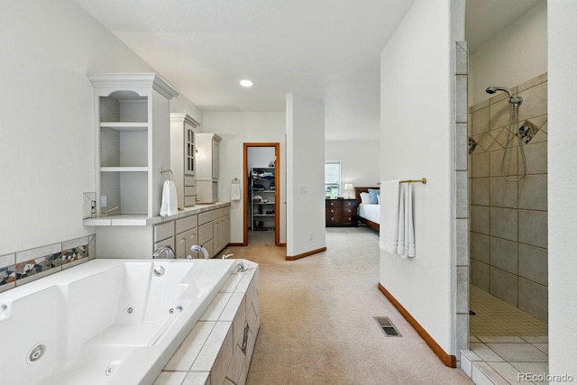 3 Desert Inn Way, Colorado Springs, CO 80921 - bathroom featuring a jetted tub, walk in shower, ensuite bathroom, baseboards, and a walk in closet