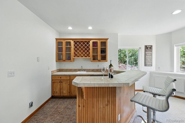 3 Desert Inn Way, Colorado Springs, CO 80921 - kitchen with a sink, baseboards, brown cabinets, recessed lighting, and glass insert cabinets