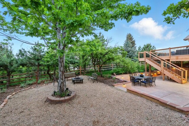 3 Desert Inn Way, Colorado Springs, CO 80921 - fenced backyard with a wooden deck, stairway, a patio area, and a fire pit