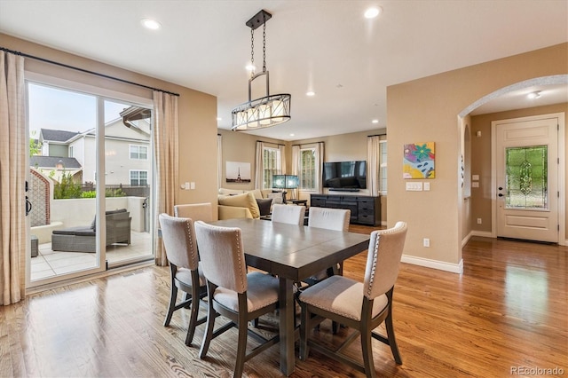 8526 E 35th Ave, Denver, CO 80238 - dining space featuring arched walkways, light wood finished floors, and recessed lighting