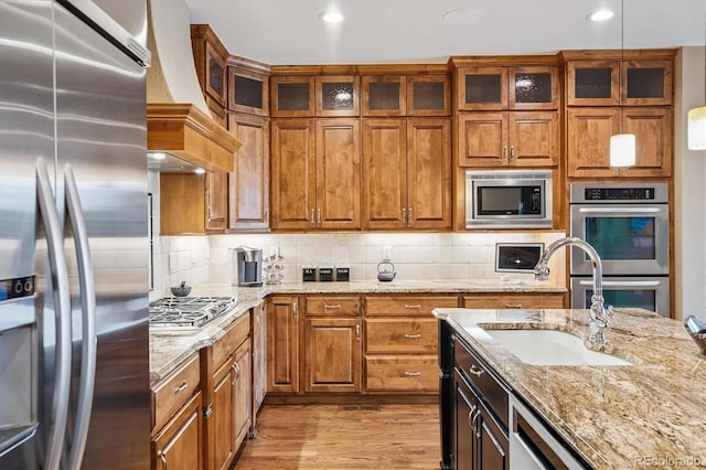 8526 E 35th Ave, Denver, CO 80238 - kitchen featuring appliances with stainless steel finishes, custom exhaust hood, light wood-style flooring, light stone countertops, and recessed lighting