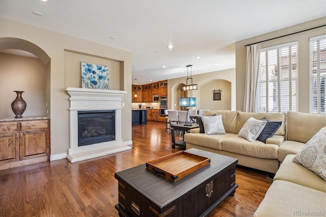 8526 E 35th Ave, Denver, CO 80238 - living room with arched walkways, dark wood-style flooring, a glass covered fireplace, and recessed lighting