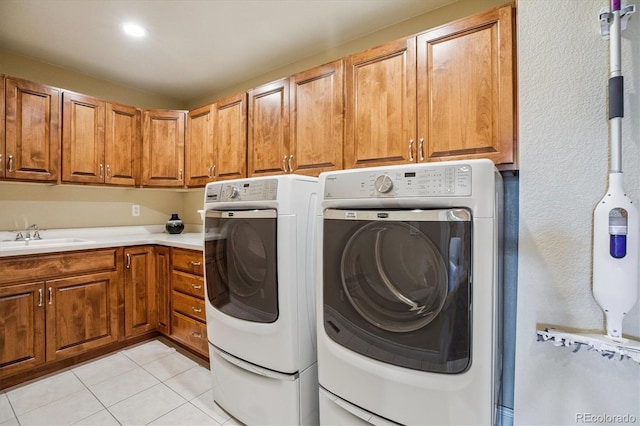 8526 E 35th Ave, Denver, CO 80238 - washroom featuring washing machine and clothes dryer, light tile patterned floors, and cabinet space