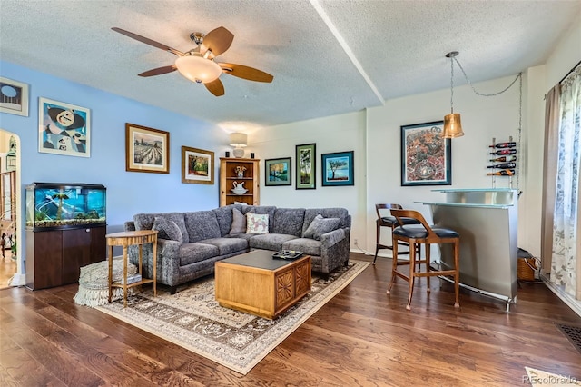 1559 Elm St, Denver, CO 80220 - living area with a textured ceiling, dark wood-type flooring, a ceiling fan, bar area, and arched walkways