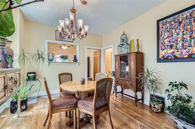 1559 Elm St, Denver, CO 80220 - dining room featuring a chandelier, wood finished floors, baseboards, and a textured ceiling