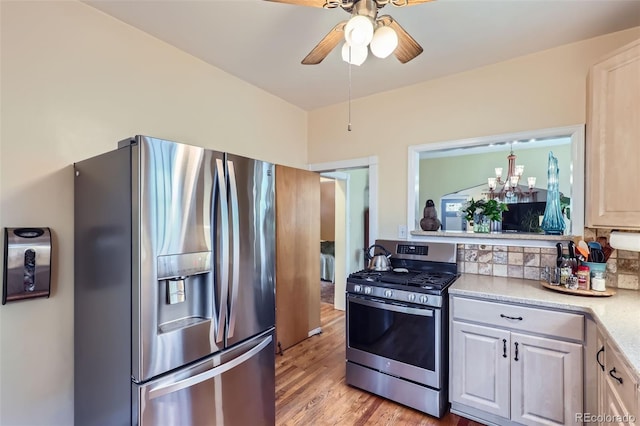 1559 Elm St, Denver, CO 80220 - kitchen featuring stainless steel appliances, light countertops, light wood-type flooring, a ceiling fan, and backsplash