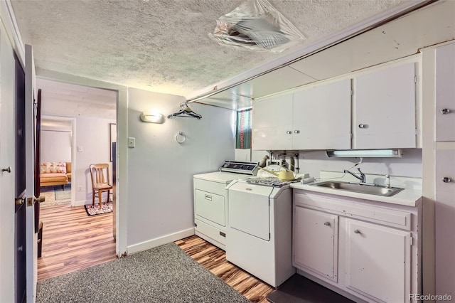 1559 Elm St, Denver, CO 80220 - kitchen with independent washer and dryer, a sink, a textured ceiling, light wood-type flooring, and light countertops