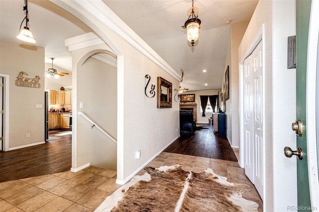 hallway with tile patterned flooring, crown molding, and lofted ceiling