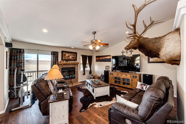 living room with ceiling fan, lofted ceiling, dark hardwood / wood-style flooring, and a tile fireplace