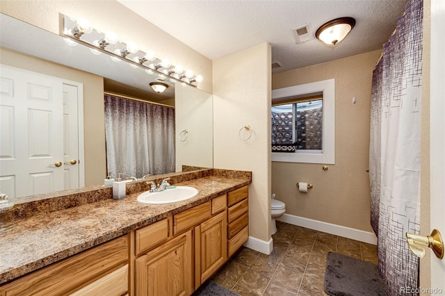 bathroom featuring vanity, a textured ceiling, and toilet