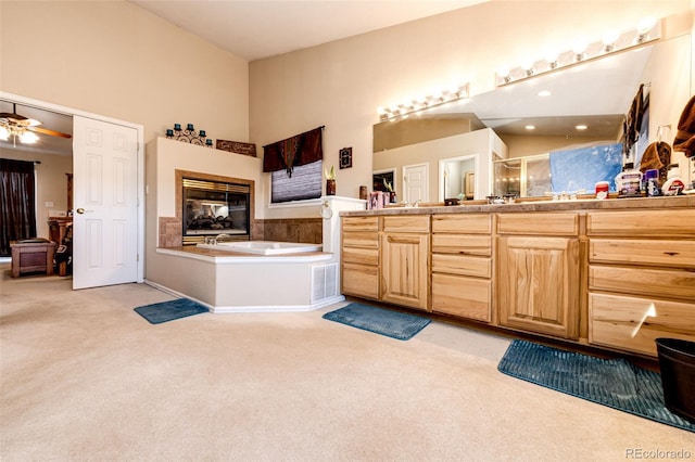 bathroom featuring ceiling fan, vanity, and shower with separate bathtub