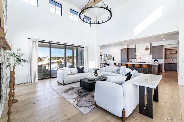 living room featuring a towering ceiling and light hardwood / wood-style flooring