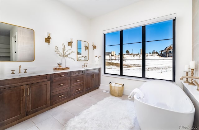 bathroom with a bathtub, vanity, and tile patterned flooring