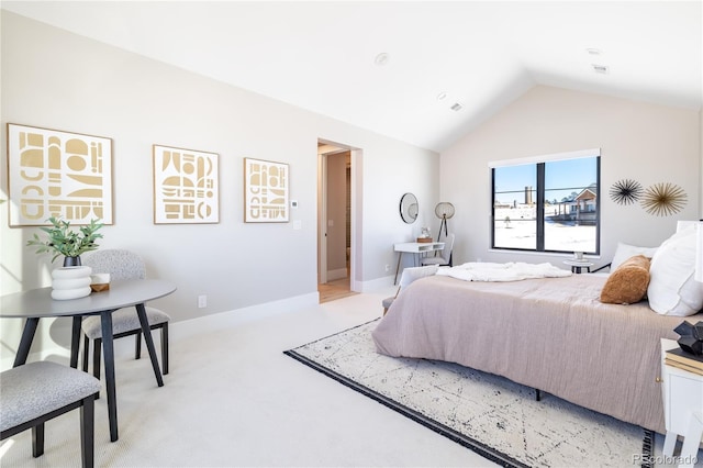 bedroom featuring light carpet and vaulted ceiling