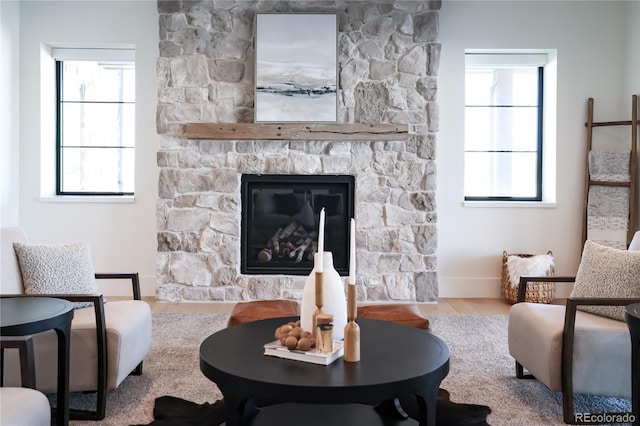 living room with wood-type flooring, a fireplace, and plenty of natural light