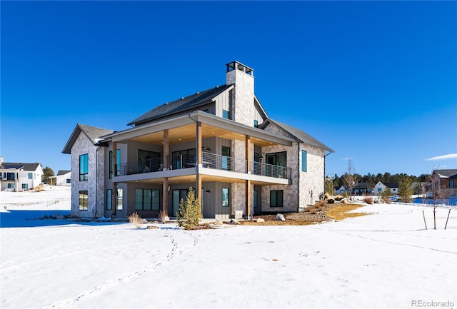 snow covered property with a balcony