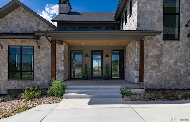 2442 Fox View Trl, Franktown, CO 80116 - property entrance featuring stone siding, covered porch, a chimney, and board and batten siding