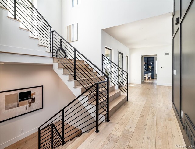 2442 Fox View Trl, Franktown, CO 80116 - entryway with stairs, wood-type flooring, a high ceiling, and baseboards
