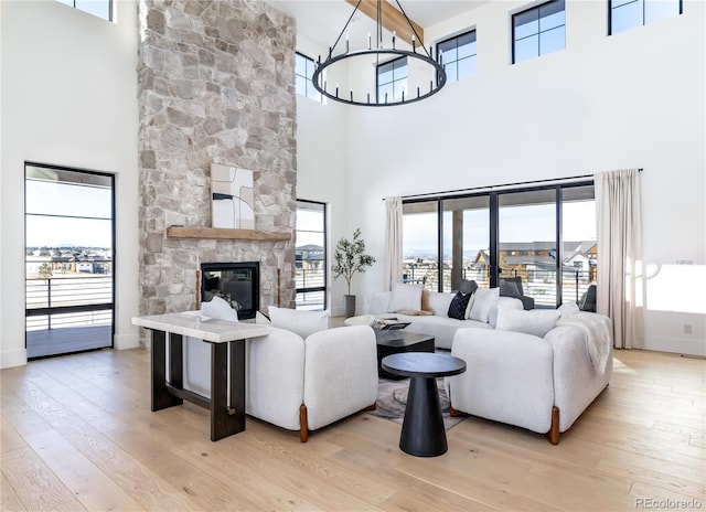 2442 Fox View Trl, Franktown, CO 80116 - living room featuring a towering ceiling, a chandelier, light wood-style flooring, and plenty of natural light