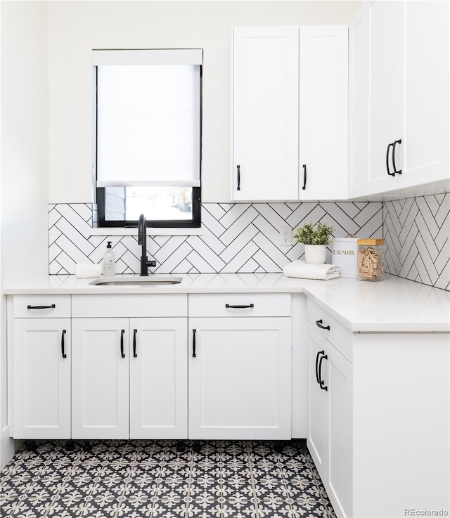 2442 Fox View Trl, Franktown, CO 80116 - kitchen with a sink, tile patterned floors, white cabinetry, light countertops, and decorative backsplash
