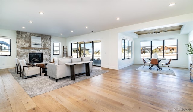 2442 Fox View Trl, Franktown, CO 80116 - living area with light wood-style floors, healthy amount of natural light, recessed lighting, a stone fireplace, and baseboards