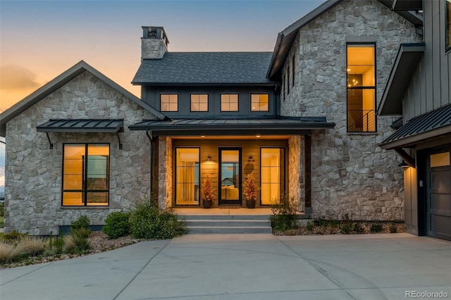 2442 Fox View Trl, Franktown, CO 80116 - back of house featuring stone siding, a standing seam roof, a chimney, and covered porch