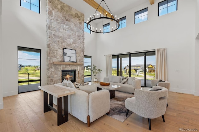 2442 Fox View Trl, Franktown, CO 80116 - living area featuring a high ceiling, a chandelier, light wood-style floors, and a fireplace