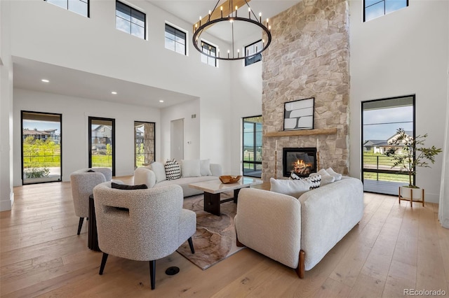 2442 Fox View Trl, Franktown, CO 80116 - living room featuring a high ceiling, light wood-style flooring, a chandelier, and a fireplace