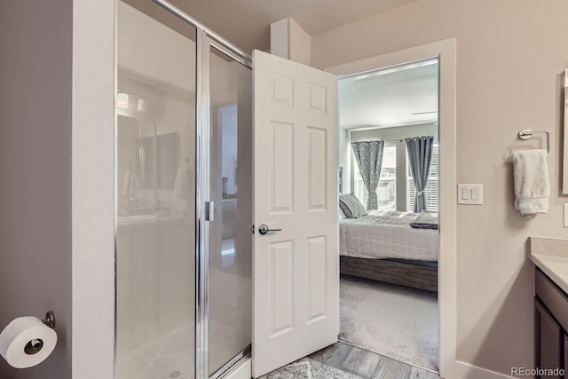 bathroom featuring hardwood / wood-style floors, vanity, and a shower with shower door