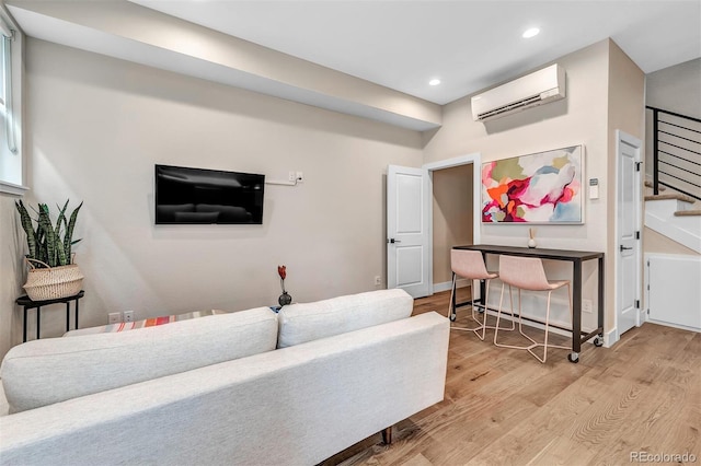 living area featuring recessed lighting, wood finished floors, baseboards, stairway, and a wall mounted AC