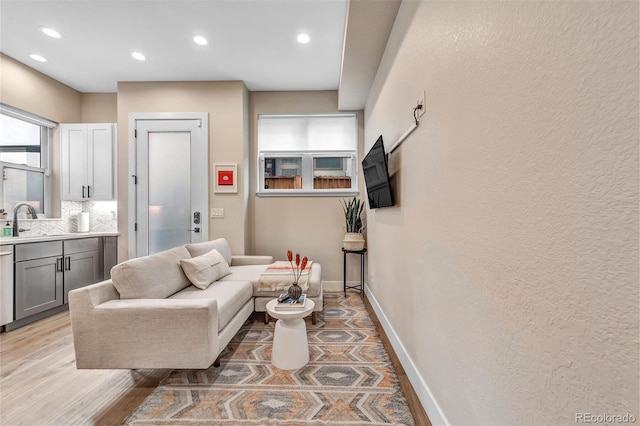 living area featuring recessed lighting, light wood-style flooring, and baseboards