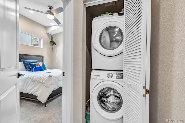 washroom with laundry area, a ceiling fan, a textured wall, stacked washer and clothes dryer, and carpet flooring