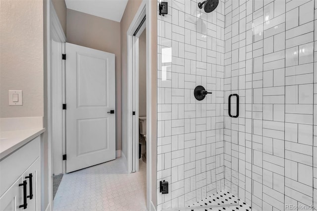 bathroom featuring toilet, a shower stall, tile patterned flooring, and vanity