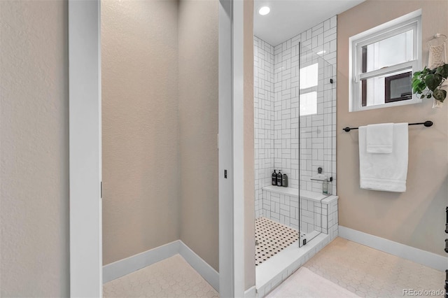 full bathroom with a stall shower, baseboards, and tile patterned floors